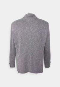 Bakifrån av en långärmad, grå texturerad blazer med slagkrage och knäppta manschetter mot en vit bakgrund.