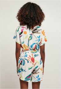 Kleurige bloemenprint rompert met korte mouwen, lichtgewicht stof, een cinched taille en losse broeken. Heeft levendige patronen in meerdere kleuren.