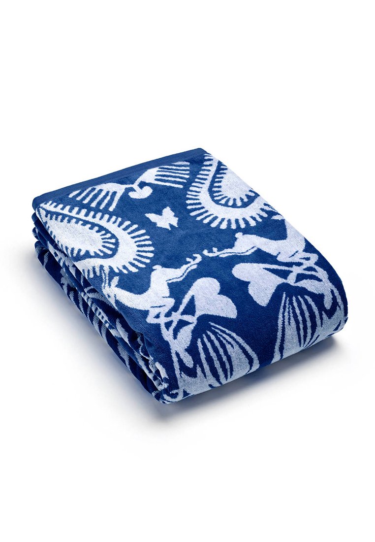 Serviette bleue, texture douce, avec des motifs floraux et abstraits blancs. Pliée soigneusement avec un riche contraste de couleurs et des détails de motifs complexes.
