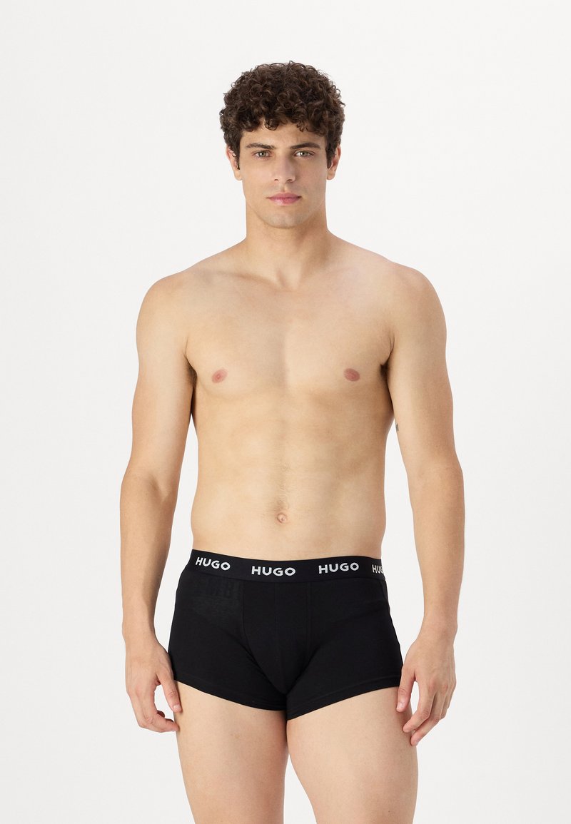 Boxer da uomo neri con una cintura elastica brandizzata. Il materiale appare liscio e aderente, mostrando una forma standard di trunk.