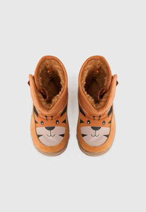 Orangene Stiefel mit einem Tigerkopfdesign, ausgestattet mit einem weichen, fellgefütterten Innenleben und schwarzen Akzenten. Abgerundete Form mit einer strukturierten, langlebigen Sohle.