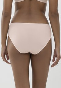 Jasnoróżowa, bezszwowa bielizna o wysokim kroju. Miękka, elastyczna tkanina dopasowuje się do ciała, z gładkimi krawędziami i minimalnym przeszyciem.