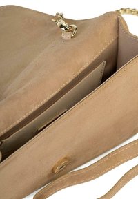 Beżowa skórzana torebka z suedowej skóry z łańcuchem i skórzanym paskiem. Wnętrze ma kieszeń i zapięcie na zatrzask. Gładka faktura z schludnymi detalami ściegów.