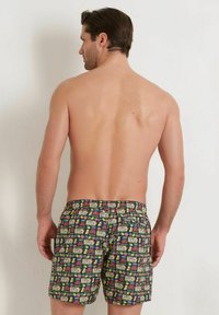 Costumi da bagno con uno sfondo scuro e motivi colorati di frutta e console di gioco, vita elastica e design dalla vestibilità comoda.