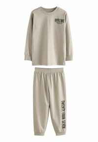 Haut beige à manches longues avec un motif "OFFLINE" et un pantalon assorti avec l'impression "TWENTY FOUR SEVEN". Fabriqué à partir d'un matériau doux et extensible.