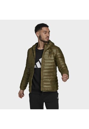 Olijfgroene pufferjack met een ritssluiting aan de voorkant, capuchon en gestikte patroon; gedragen over een zwarte sweatshirt met een witte grafische print.