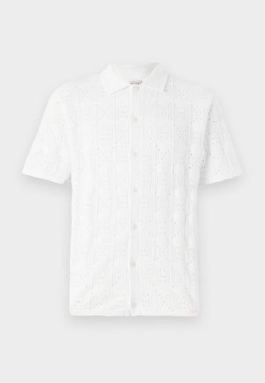 Weißes kurzärmliges Hemd mit einem strukturierten Gittermuster und kleinen Perforationen, mit einem kragenförmigen Ausschnitt und fünf Knöpfen auf der Vorderseite.