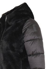 Giacca nera foderata in pelliccia con maniche in nylon imbottito e trapuntato, colletto alto e chiusura con zip. Toppa con logo sulla manica.
