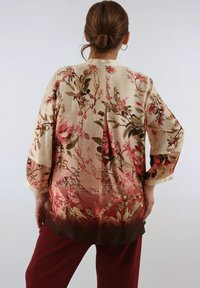 Floral kimono with a lightweight, silky texture, featuring pink and green flowers on a cream background, transitioning to deep red at the hem.