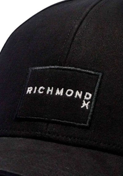 Cappello nero in cotone con visiera piatta, caratterizzato da una toppa rettangolare con il testo ricamato bianco "RICHMOND X" centrato sulla parte frontale.