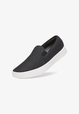 Dunkelgrauer Slipper-Sneaker mit elastischen Seiteneinsätzen und dicker weißer Gummisohle, vor weißem Hintergrund dargestellt.