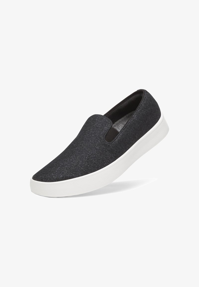 Sneaker grigio scuro senza lacci con pannelli laterali elastici e suola spessa in gomma bianca, mostrato su uno sfondo bianco.