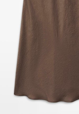 Brown skirt with a subtle textured pattern, shown hanging against a white background, highlighting fabric details and hemline.