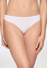 Slip in cotone bianco con design senza cuciture, texture morbida e vita bassa. Stile minimalista e basic.