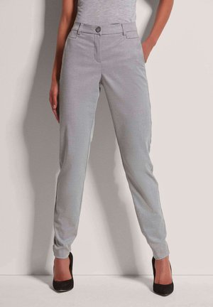 Lichtgrijze, op maat gemaakte broek met een gladde textuur, voorzien van een knoopsluiting en zijzakken. De broekspijpen zijn slim-fit en worden gecombineerd met zwarte hoge hakken.