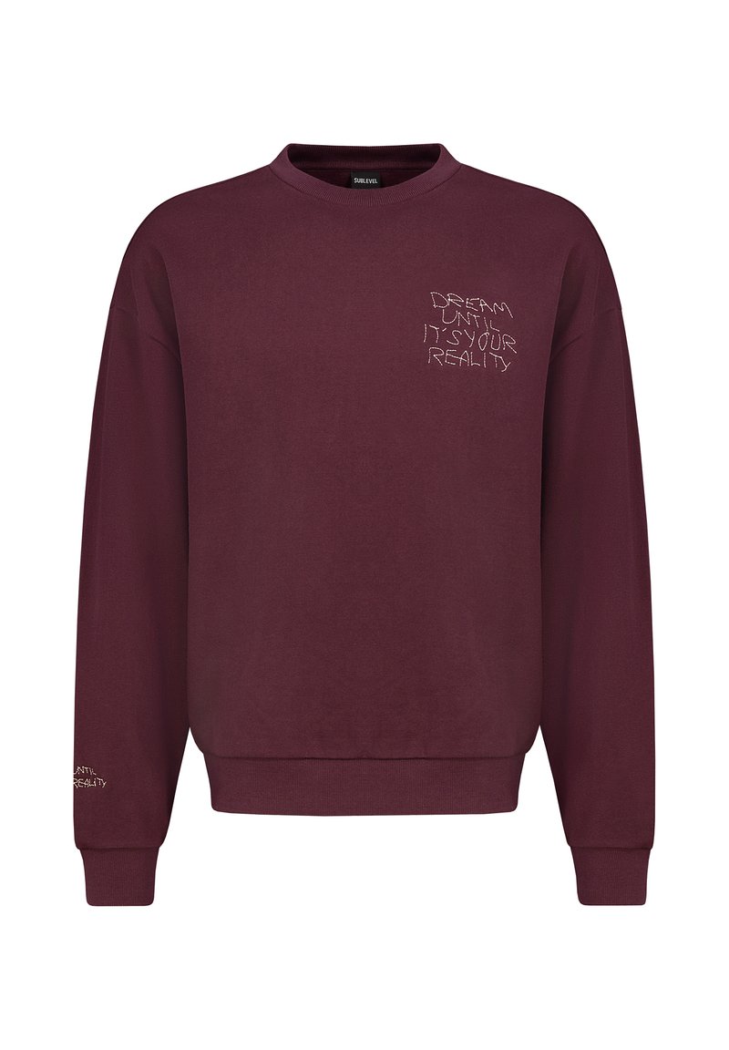 Bordeaux sweatshirt met een ribgebreide ronde hals en lange mouwen. Heeft witte geborduurde tekst op de voorkant en de linker mouw.