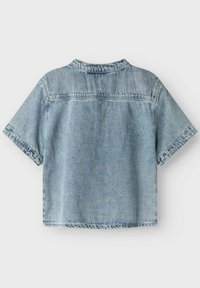 Camicia di jeans accorciata in azzurro chiaro, con maniche corte, colletto classico e dettagli di orlo sfrangiato. La vista posteriore mostra un design semplice senza motivi.