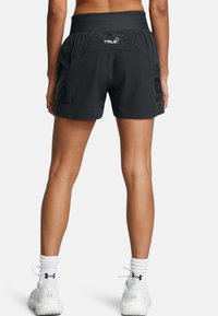 Shorts deportivos negros con una cintura ajustada, que cuentan con bolsillos laterales y un logo en la parte trasera. Textura suave, diseño ligero.