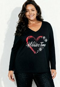 Zwart shirt met lange mouwen en V-hals, bedrukt met een rood hart en de tekst "It's Winter Time" samen met witte sneeuwvlokken.