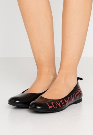 Skinnende sorte balletflader har en rund tå og en sidelogo i rød tekst, der står "LOVE MOSCHINO." Glat overflade med minimal hardware.