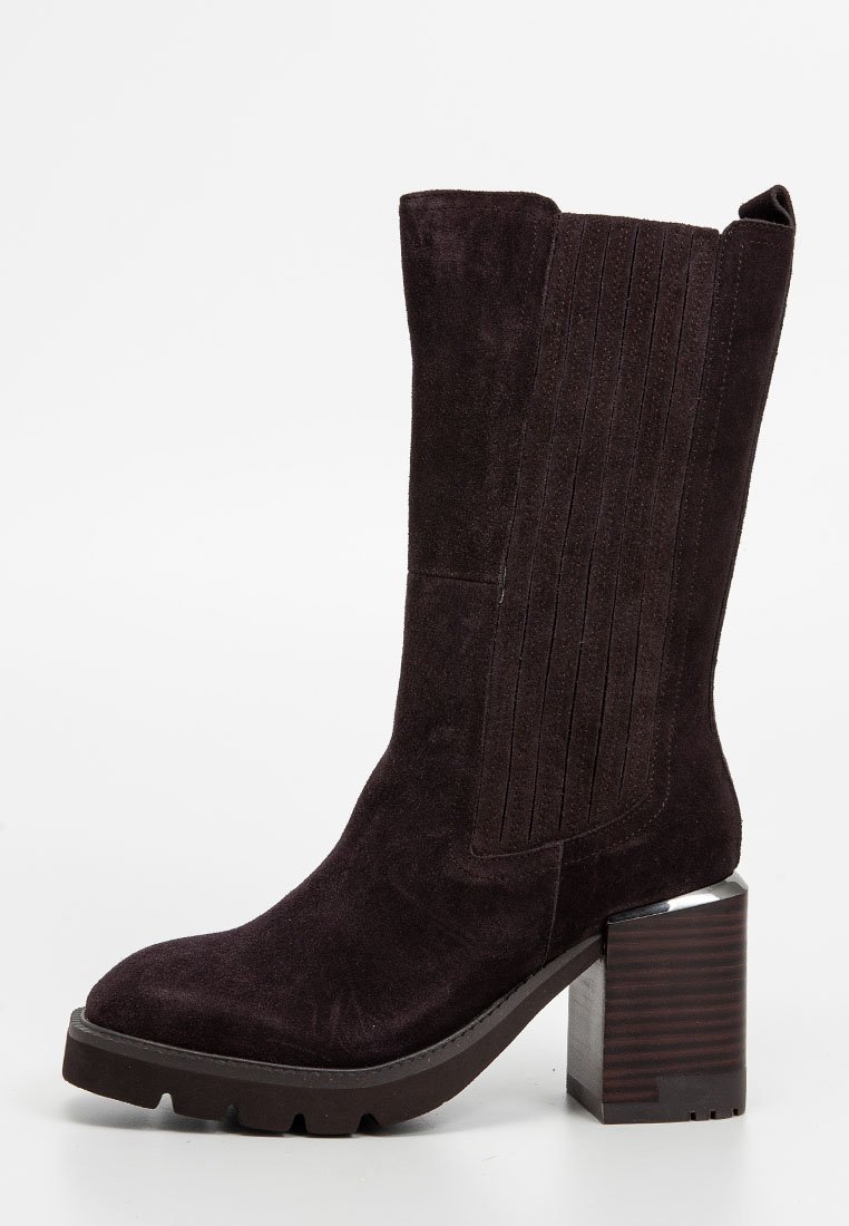Ciemnofioletowy zamszowy botek za kostkę z kwadratowym noskiem, żłobieniami po bokach oraz masywnym, błyszczącym metalowym obcasem. Wzorzysta podeszwa zapewniająca przyczepność.