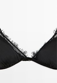 Czarny stanik z trójkątnymi miskami, przezroczystą koronką z postrzępionymi brzegami, marszczonym materiałem u podstawy oraz prostym zapięciem na haczyk z tyłu.