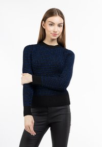 Maglione lavorato a maglia con base nera e dettagli a motivo blu e bianco, polsini e orlo a coste. Maniche lunghe con scollatura rotonda.