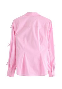 Camicia rosa a maniche lunghe con polsini abbottonati, caratterizzata da piccoli fiocchi sulle maniche e un design a colletto classico, realizzata in un tessuto liscio.