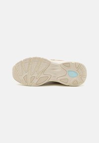 Light beige athletic shoe sole with textured patterns and grooves for traction; includes blue accent detail.