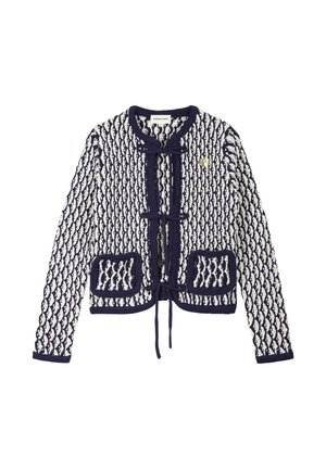 Marineblauwe en witte gebreide cardigan met diamantenpatroon, sluiting met strik aan de voorkant, twee voorzakken en een kleine gouden hartspeld op de linkerborst.