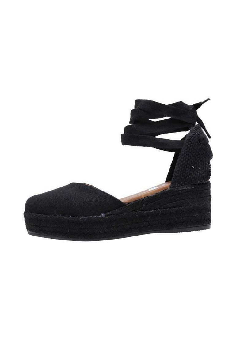 Wedge de esparto negro con parte superior de lona, suela de yute trenzado y correas cruzadas en el tobillo. Punta redonda y tacón texturizado.