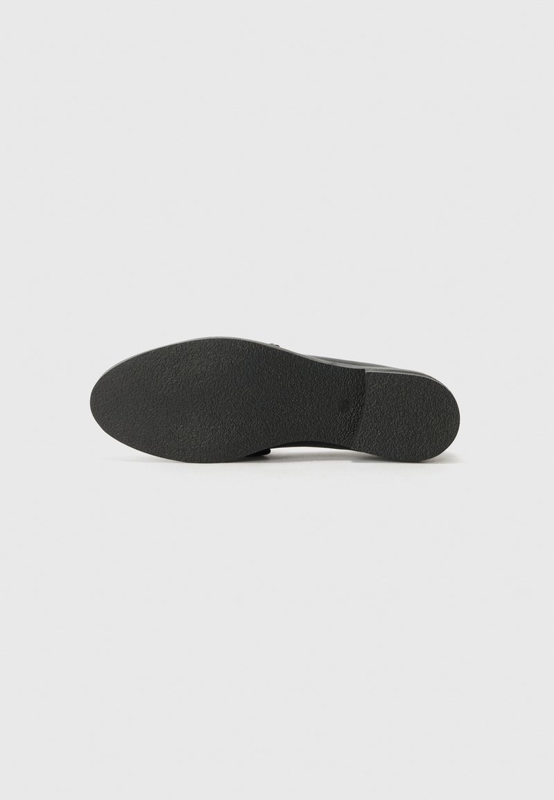 Sola di scarpa nera con superficie in gomma testurizzata, caratterizzata da una forma arrotondata e una leggera curvatura per supporto. Design pulito senza marcature visibili.