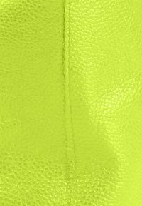 Neon groen geruwd leer met een fijne korrel, voorzien van een subtiele naad die verticaal loopt, wat duurzaamheid en een levendige kleur uitstraalt.