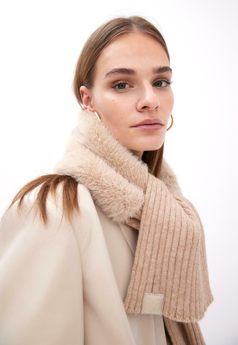 Beige ribbet strik scarf med en luksuriøs fake fur krave, prydet med et logo. Materialet fremstår blødt og struktureret, velegnet til koldere vejr.
