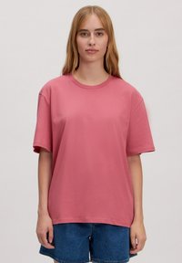 Roze katoenen t-shirt met korte mouwen en een ronde hals, met een relaxte pasvorm en een gladde textuur. Draag het met denim shorts.