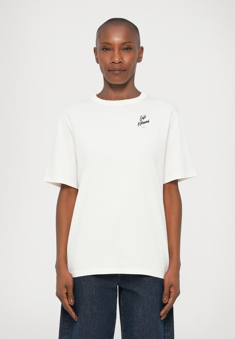 T-shirt bianco a maniche corte in cotone con scollatura a girocollo, caratterizzato da un piccolo logo nero stampato sul lato sinistro del petto. Vestibilità casual.