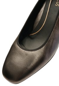 Metallic gray pump with a rounded toe, smooth leather upper, and soft black lining. Features a stitched edge around the opening.