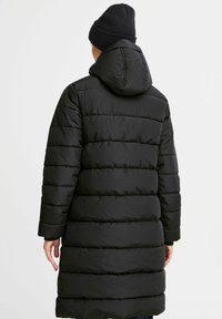 Svart boblejakke med hette, med horisontale quiltede mønstre og middels lengde, laget av lett og glatt stoff.