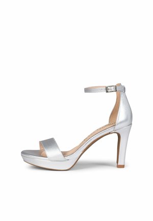 Sandalia plateada de tacón alto con hebilla en la correa del tobillo, puntera abierta y suela de plataforma delgada.
