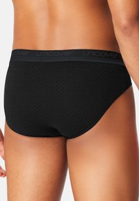 Sorte mønstrede trusser med et tekstureret diamantdesign, der har en blød elastisk talje med "uncover" logo.