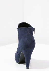 Laivastonsininen mokkanahkainen nilkkurit, joissa on pyöreä kärki ja sivuvetoketju. Kengissä on sileä pinta ja tyylikäs siluetti.