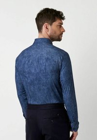 Dunkelblauses Denimhemd mit strukturiertem Finish, langen Ärmeln und einem strukturierten Kragen. Mit Yoke-Design und geknöpften Manschetten.