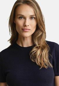 Navyblauwe gebreide ronde hals trui met korte mouwen, nauwsluitend ontwerp en een gladde textuur; minimalistische stijl zonder versieringen.