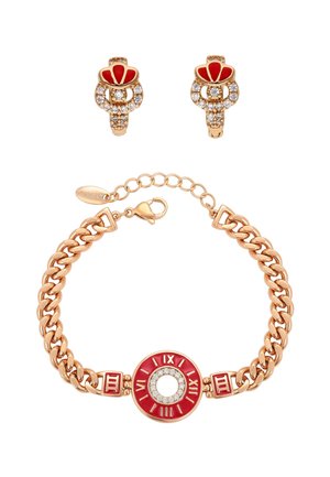 Bransoletka w złotym odcieniu z czerwoną zawieszką z rzymskimi cyframi i kryształowymi akcentami, zestawiona z pasującymi czerwonymi i kryształowymi kolczykami na sztyftach.