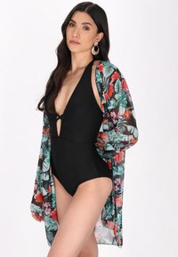 Sort heldragt svømmetøj med dyb V-hals, parret med en gennemsigtig blomsterkimono med livlige tropiske mønstre og blødt stof.