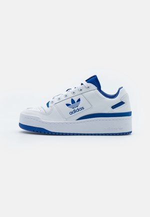 Baskets Adidas blanches et bleues avec fermeture à lacets à l'avant, logo Adidas sur le côté et semelle épaisse sur fond blanc.