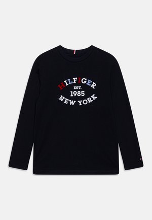 T-shirt a maniche lunghe nera in cotone, con una grafica testuale bianca, rossa e blu che recita "HILFIGER EST. 1985 NEW YORK."