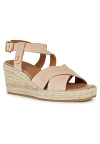 Sandale compensée en suédine beige avec des brides croisées, boucle de cheville ajustable et semelle style espadrille tressée. Semelle intérieure lisse et semelle extérieure en caoutchouc.