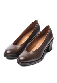 Zapatos de cuero marrón con tacón, puntera redondeada, escote bajo y tacón cuadrado. Textura suave con una costura visible a lo largo de la base.