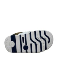 Suola di scarpa con base in gomma bianca caratterizzata da scanalature blu marine a onda, contrassegnata con "FLEXY" e "SOFTLY" vicino al tallone, con un accento circolare vicino al centro.